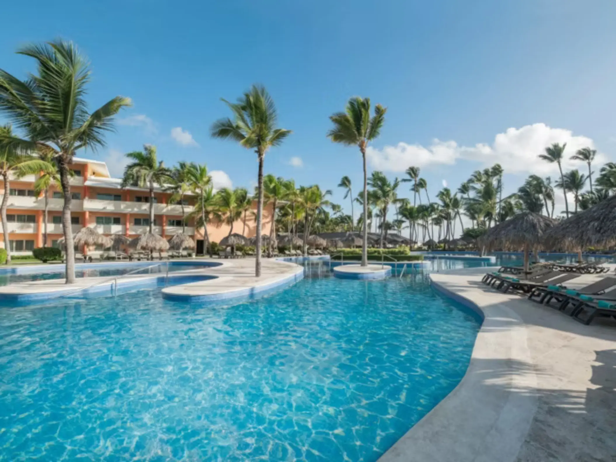 Curving outdoor swimming pool and palm trees at Iberostar Waves Dominicana, Punta Cana