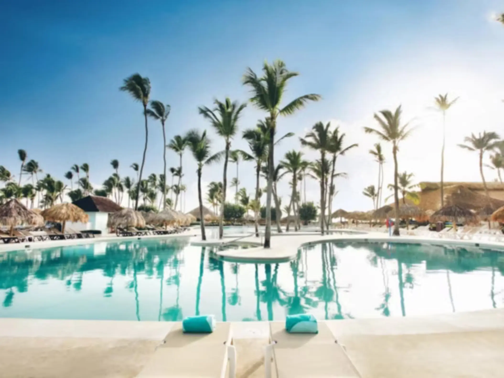 Large swimming pool with palm trees and palapas at Iberostar Waves Dominicana, Punta Cana