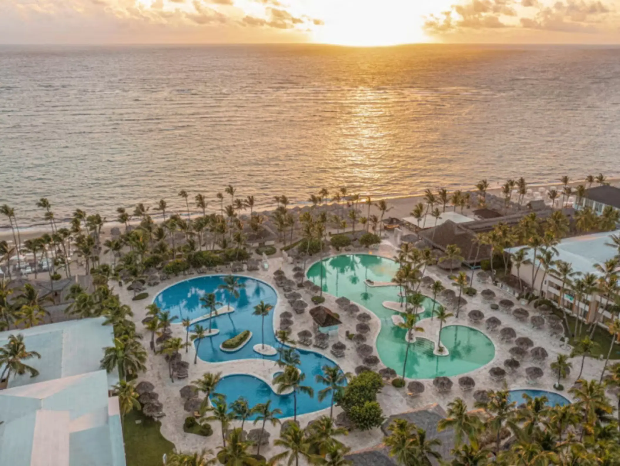 Aerial view of pools and beachfront at sunset at Iberostar Waves Dominicana, Punta Cana