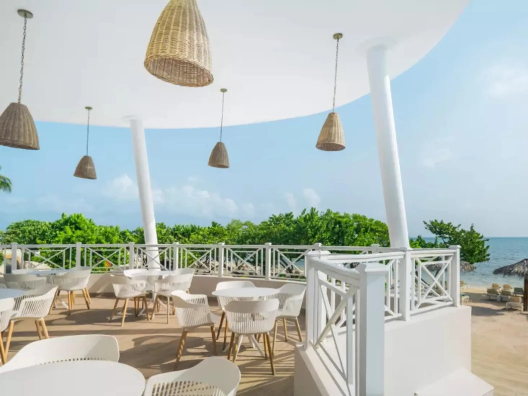 Open-air beachfront dining terrace with woven pendant lights at Iberostar Waves Rose Hall Beach, Montego Bay