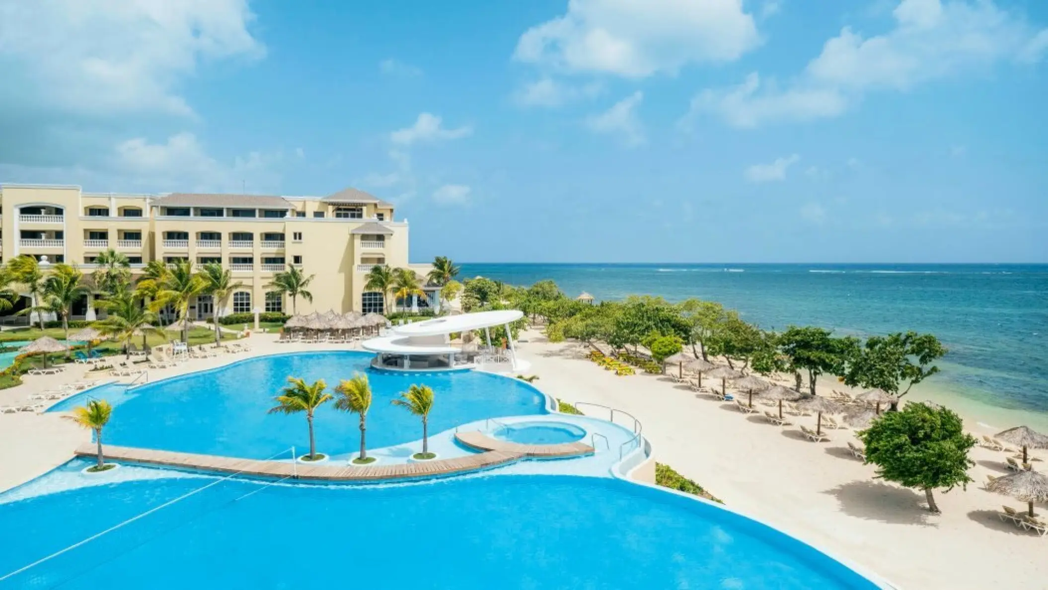 Aerial view of the swimming pools and beachfront at Iberostar Waves Rose Hall Beach, Montego Bay