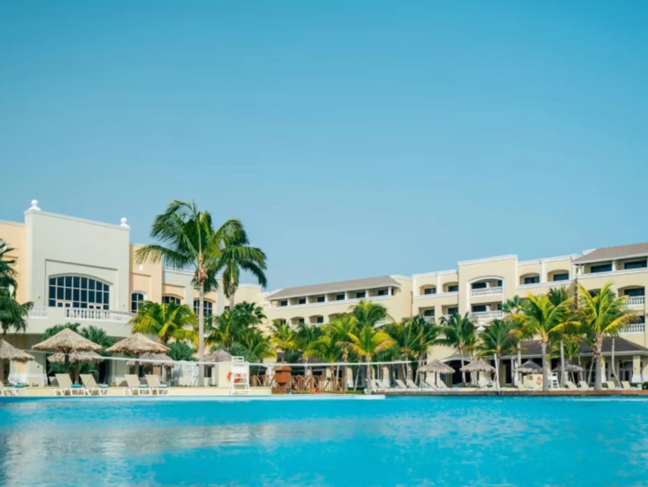 Main swimming pool and building exterior with palm trees at Iberostar Waves Rose Hall Beach, Montego Bay
