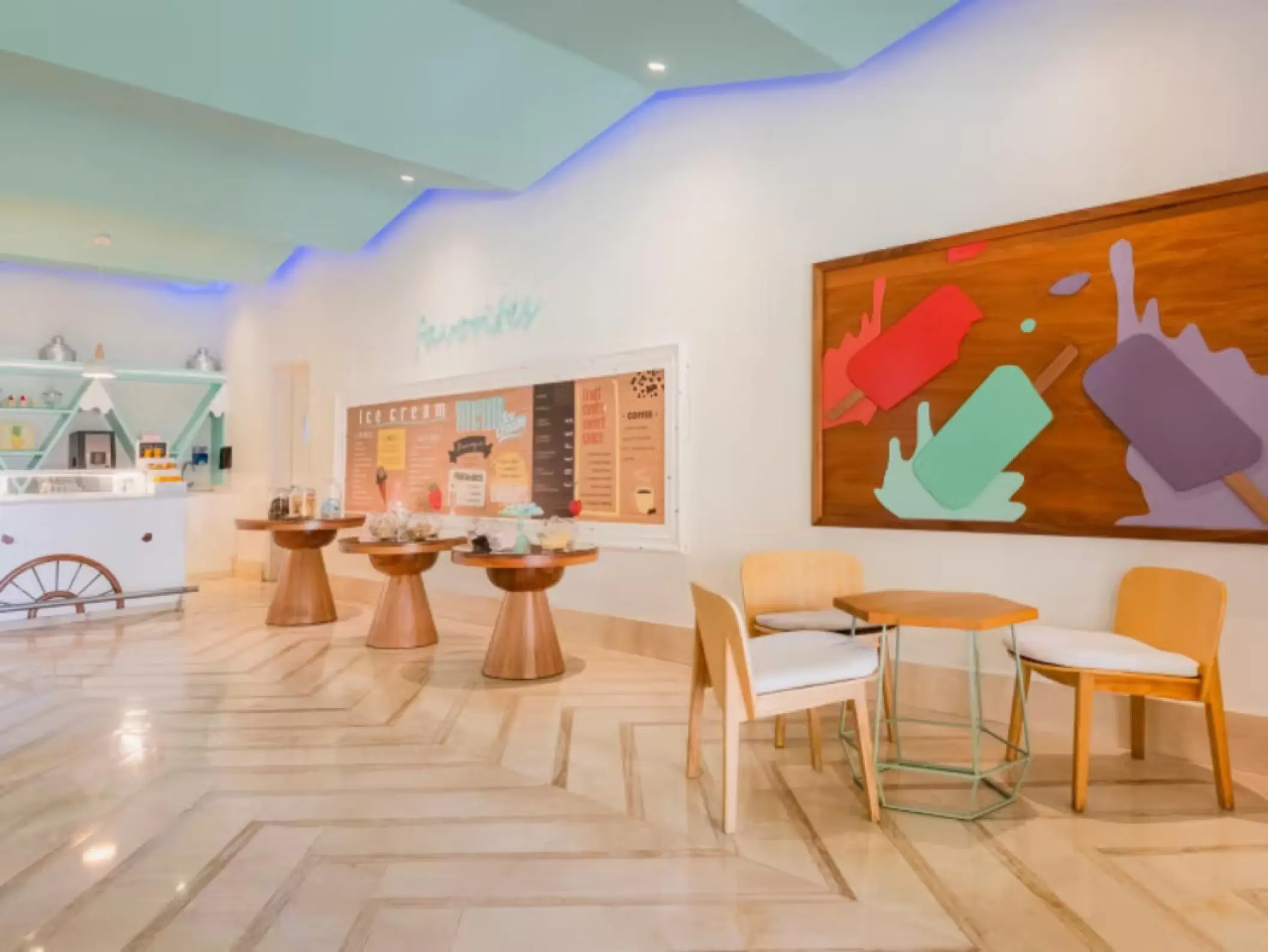 Colorful indoor ice cream shop with seating and popsicle wall art at Iberostar Rose Hall Beach, Montego Bay