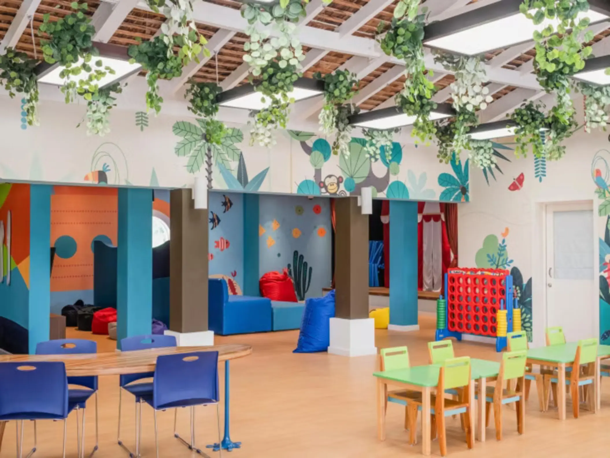 Colorful Star Camp kids club with small tables and hanging plants at Iberostar Rose Hall Beach, Montego Bay