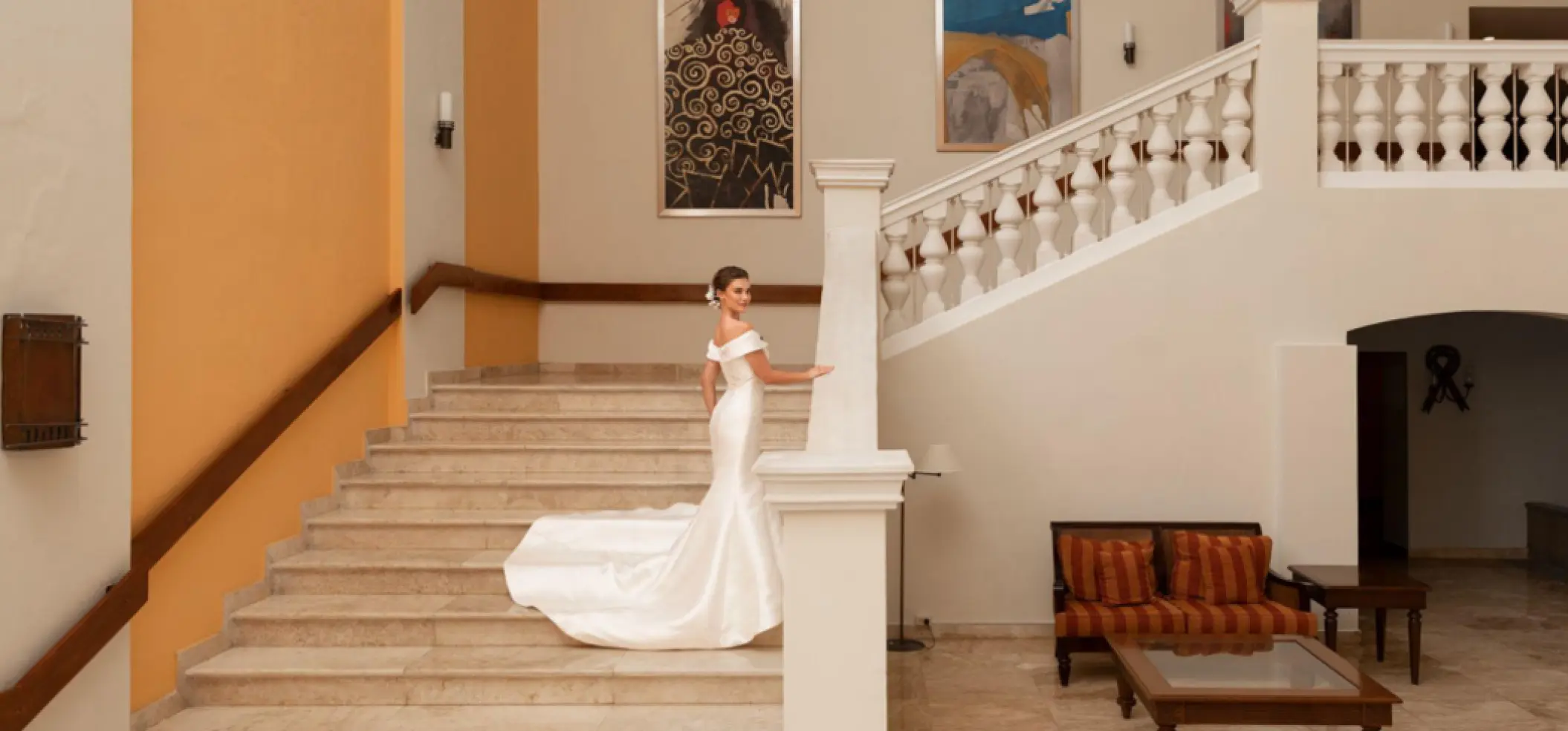 Bride posing on the grand marble staircase at Iberostar Waves Rose Hall Beach, Montego Bay