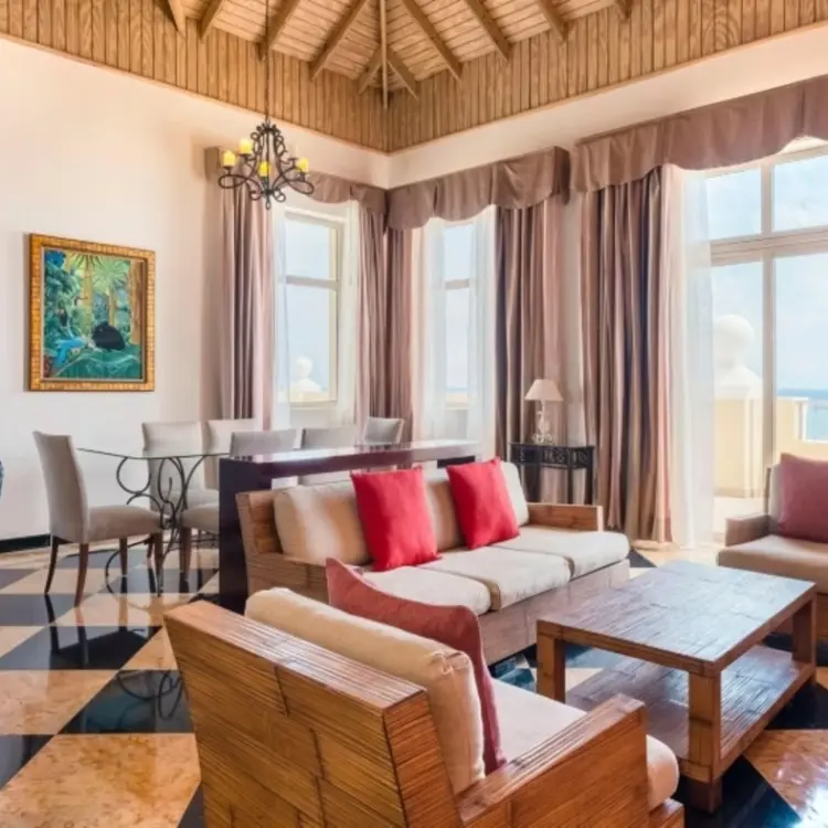 Oceanview suite living area with high ceilings and large windows at Iberostar Rose Hall Beach, Montego Bay