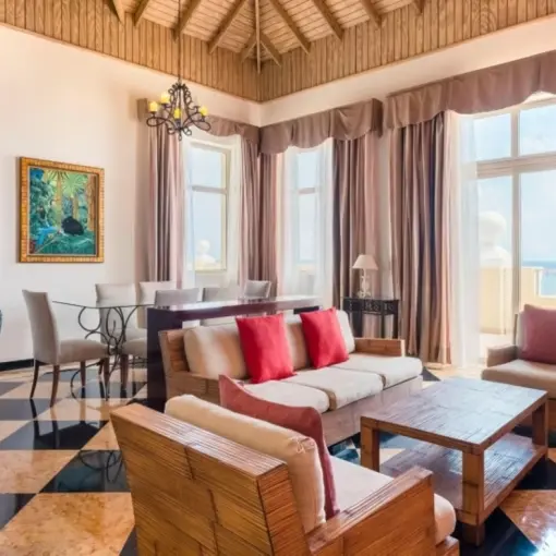 Oceanview suite living area with high ceilings and large windows at Iberostar Rose Hall Beach, Montego Bay