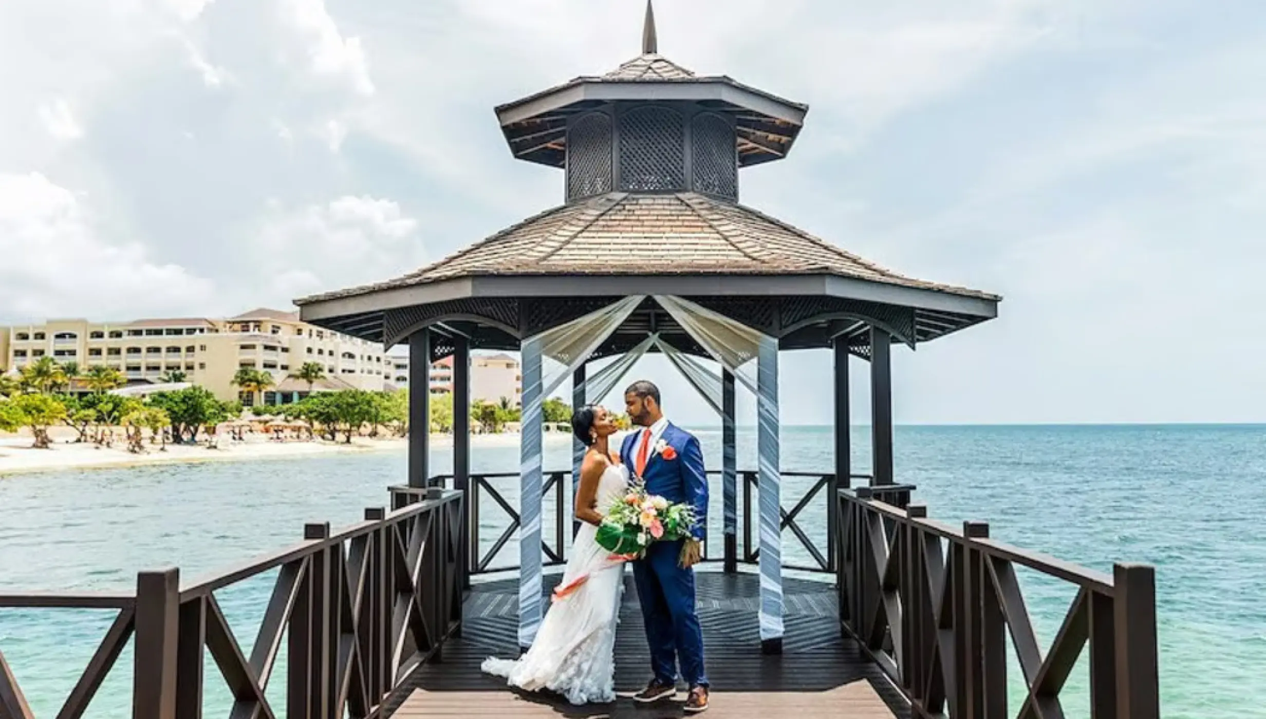 bride and groom at the pier gazebo venue at Iberostar Waves Rose Hall Beach