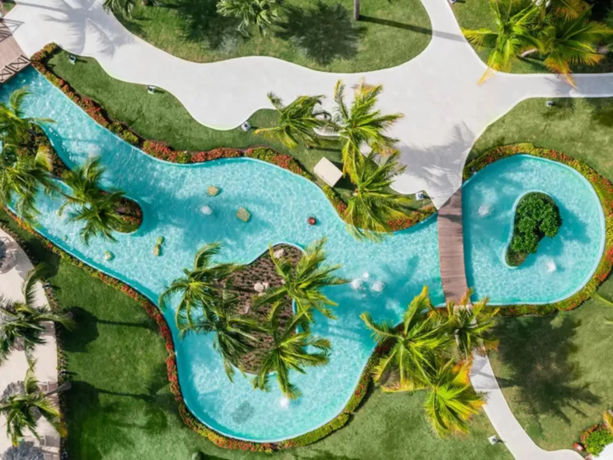 Aerial view of the lazy river pool and palm trees at Iberostar Waves Rose Hall Beach, Montego Bay