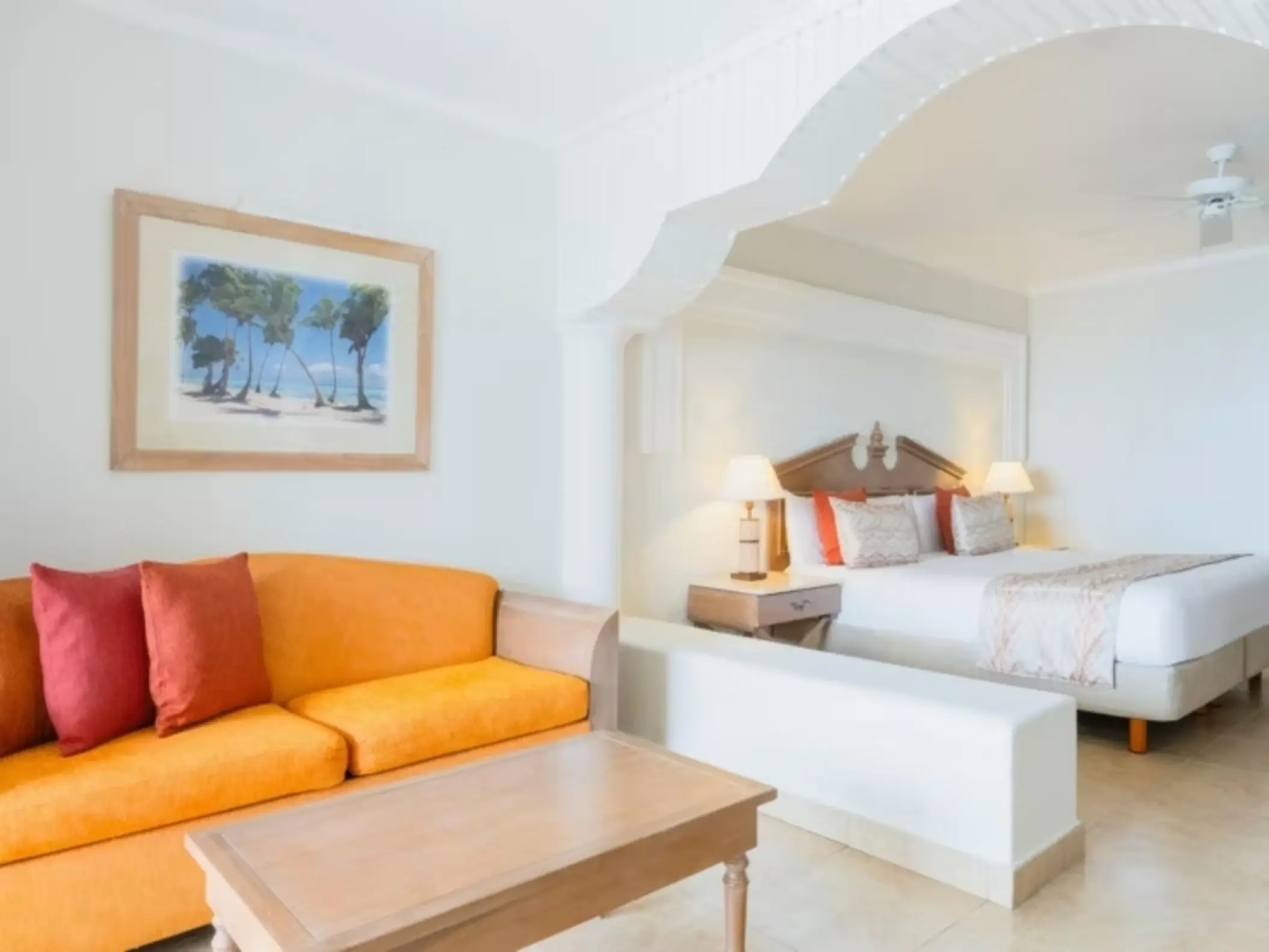 Guest room with orange sofa and king bed at Iberostar Rose Hall Beach, Montego Bay