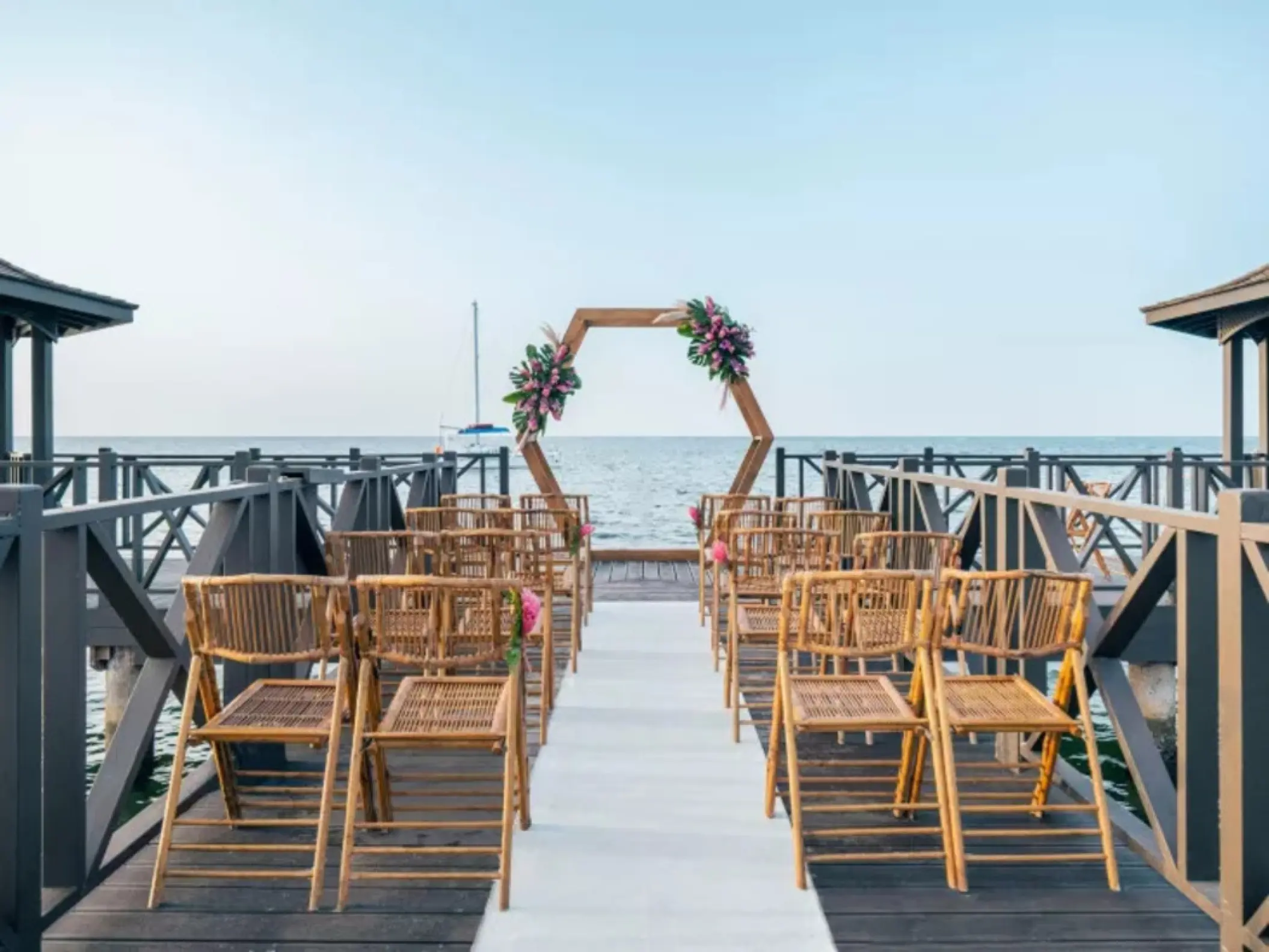 Pier wedding ceremony with a hexagonal arch at Iberostar Rose Hall Beach, Montego Bay
