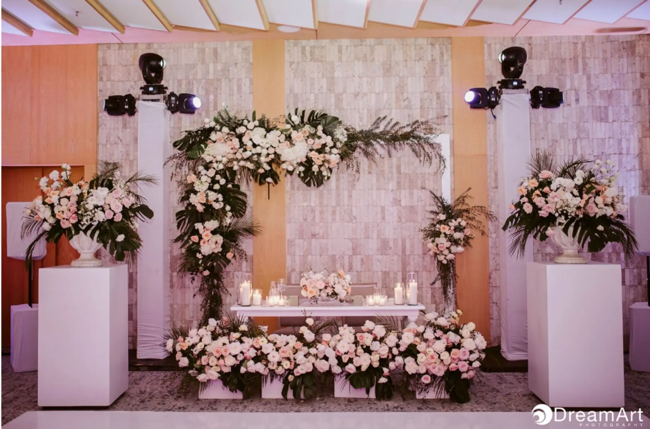 Ballroom wedding reception setup with white and pink floral arrangements at Impression Isla Mujeres
