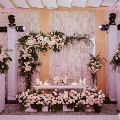 Ballroom wedding reception setup with white and pink floral arrangements at Impression Isla Mujeres