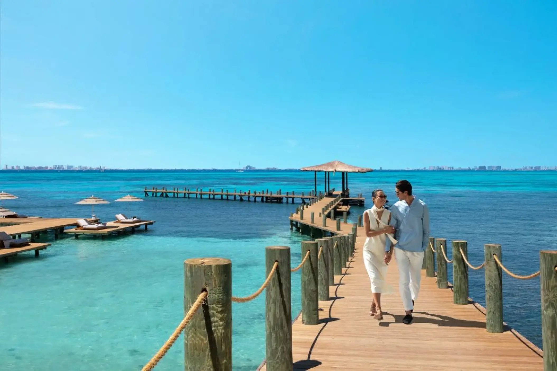Couple walking along the wooden pier at Impression Isla Mujeres, Isla Mujeres