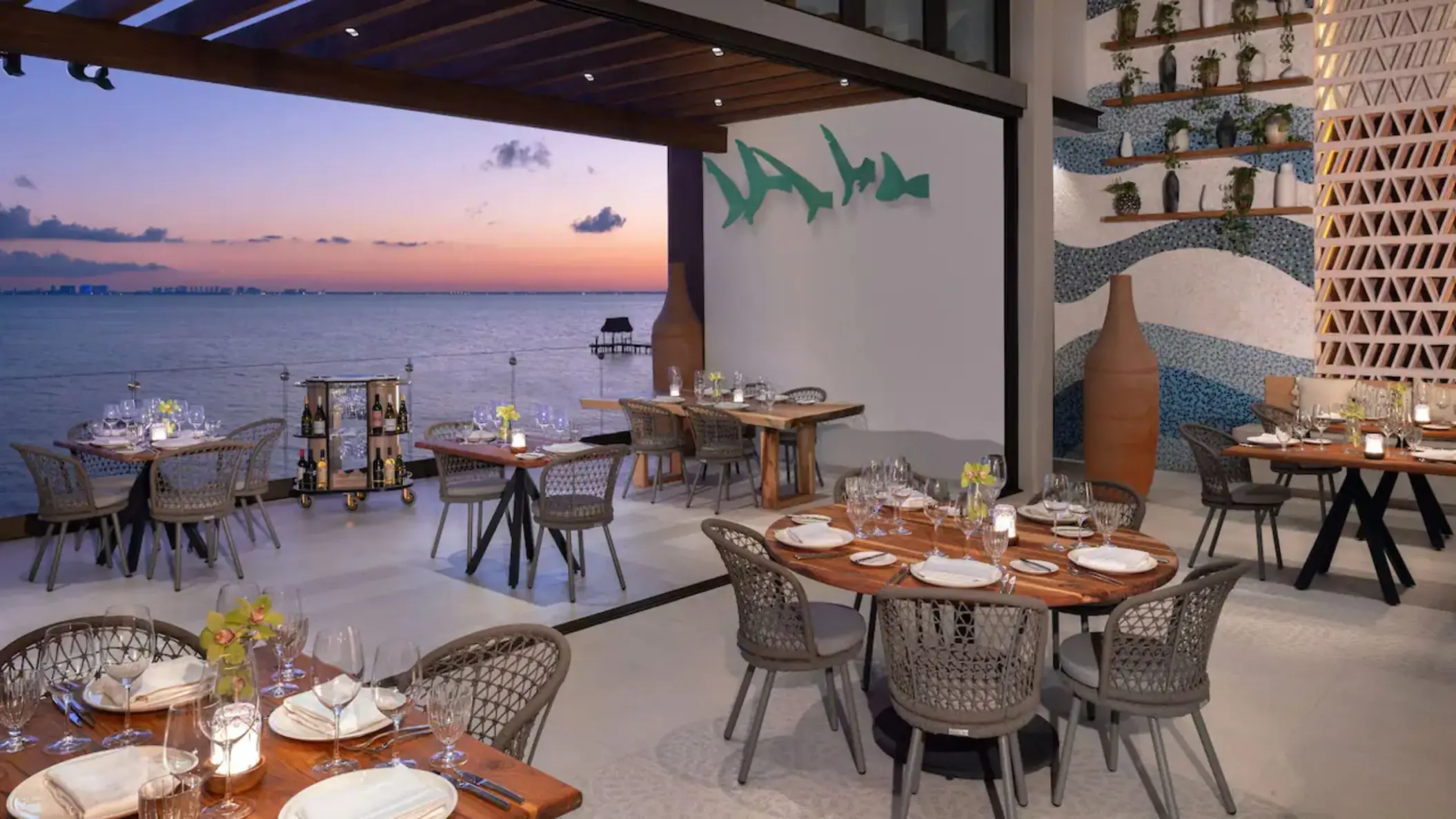 Spezia Restaurant open-air dining tables overlooking the ocean at sunset, Impression Isla Mujeres