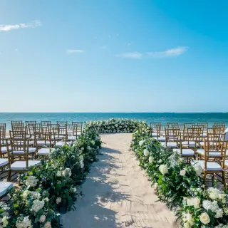 Beachfront wedding ceremony with floral aisle runners at JOIA Rose Hall by Iberostar, Montego Bay