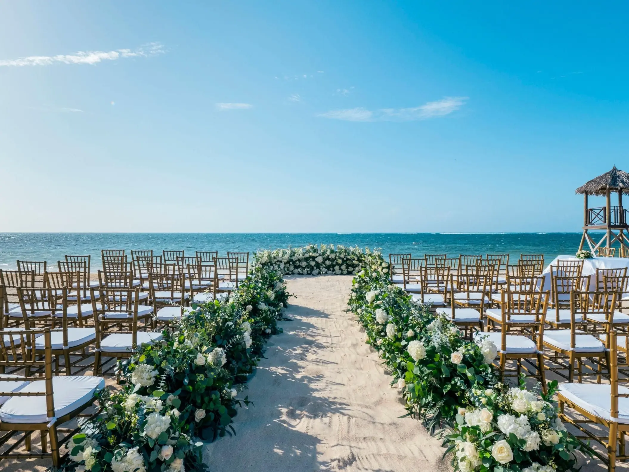 Beachfront wedding ceremony with floral aisle runners at JOIA Rose Hall by Iberostar, Montego Bay