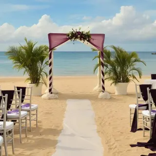 Beachfront wedding ceremony setup with purple decor at JOIA Rose Hall by Iberostar, Montego Bay