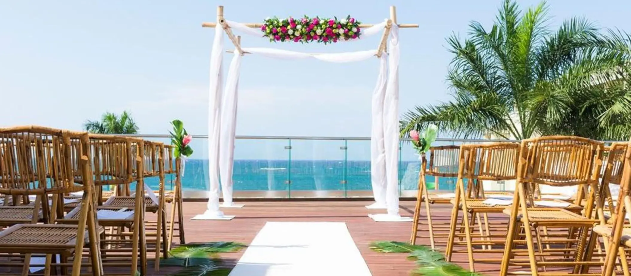 Sky deck wedding ceremony with bamboo chairs and floral arch at JOIA Rose Hall, Montego Bay