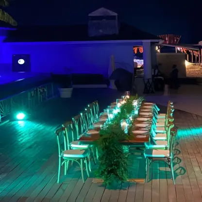 Long wooden dining table with green lighting at JOIA Rose Hall by Iberostar, Montego Bay