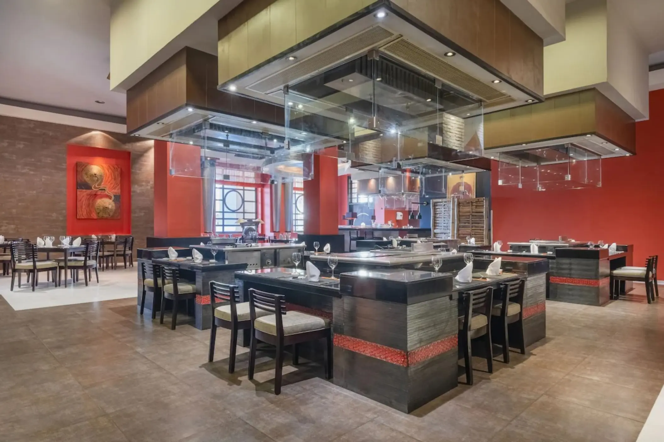 Japanese teppanyaki restaurant with set tables and red accent walls at JOIA Rose Hall by Iberostar, Montego Bay