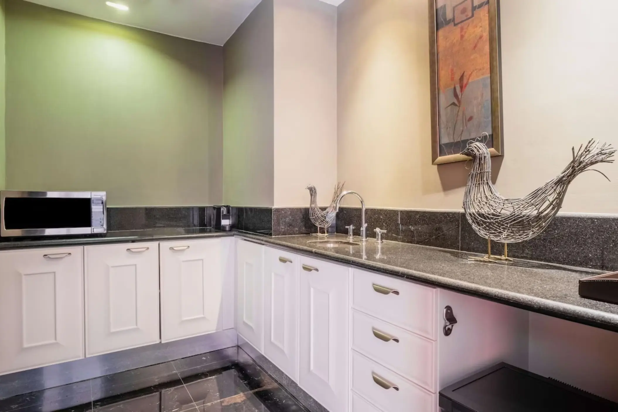 Kitchenette with white cabinets and granite countertops at JOIA Rose Hall by Iberostar, Montego Bay