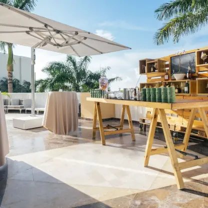 Outdoor wedding reception bar with wooden pallets and high-top tables at JOIA Rose Hall, Montego Bay