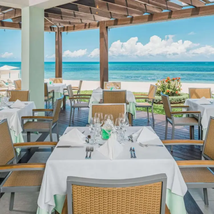 Oceanfront restaurant dining area with pergola and beach views at JOIA Rose Hall by Iberostar, Montego Bay