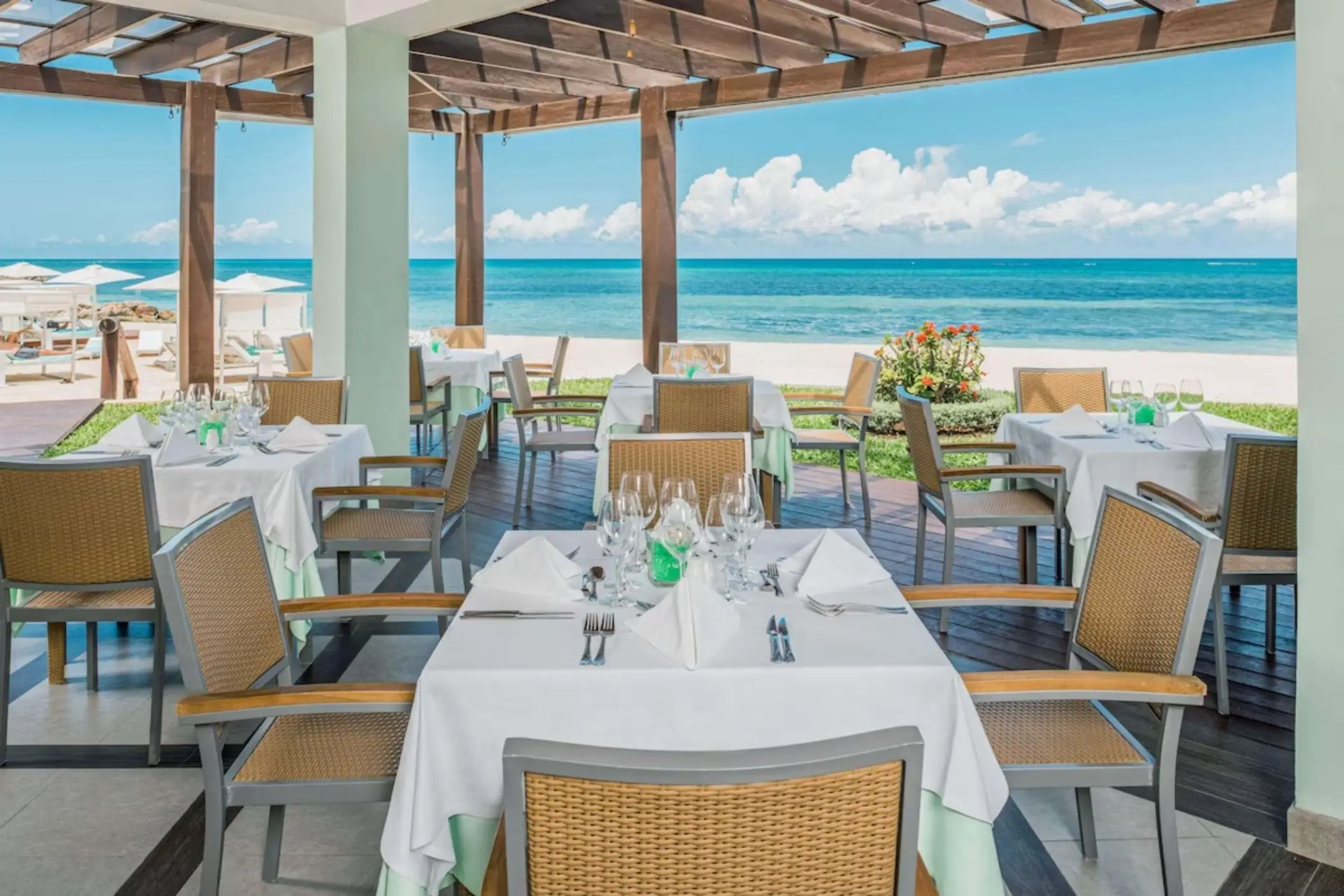 Oceanfront restaurant dining area with pergola and beach views at JOIA Rose Hall by Iberostar, Montego Bay