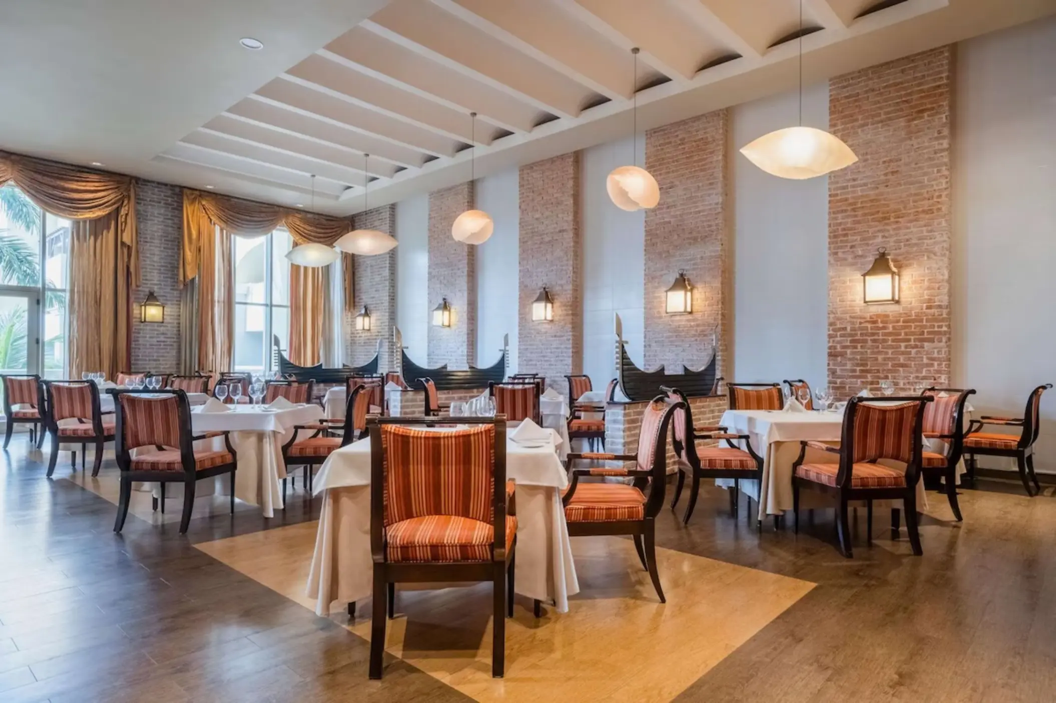Indoor restaurant with brick accents and gondola decor at JOIA Rose Hall by Iberostar, Montego Bay