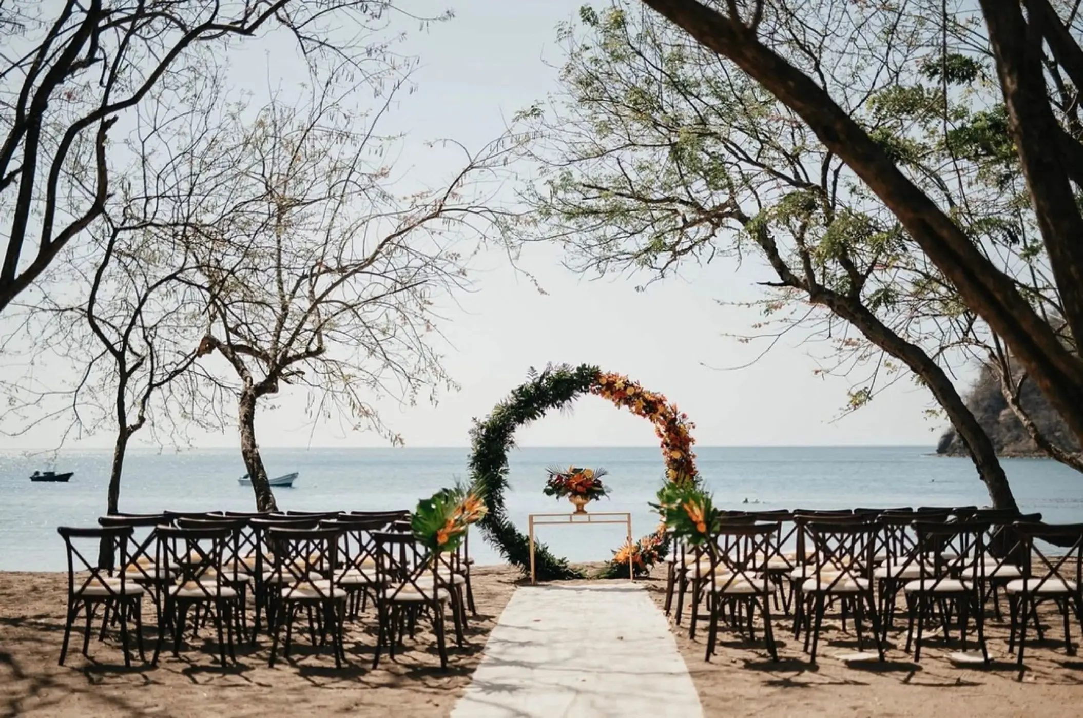 Arboleda Beach wedding ceremony setup with circular floral arch at JW Marriott Costa Elena, El Jobo
