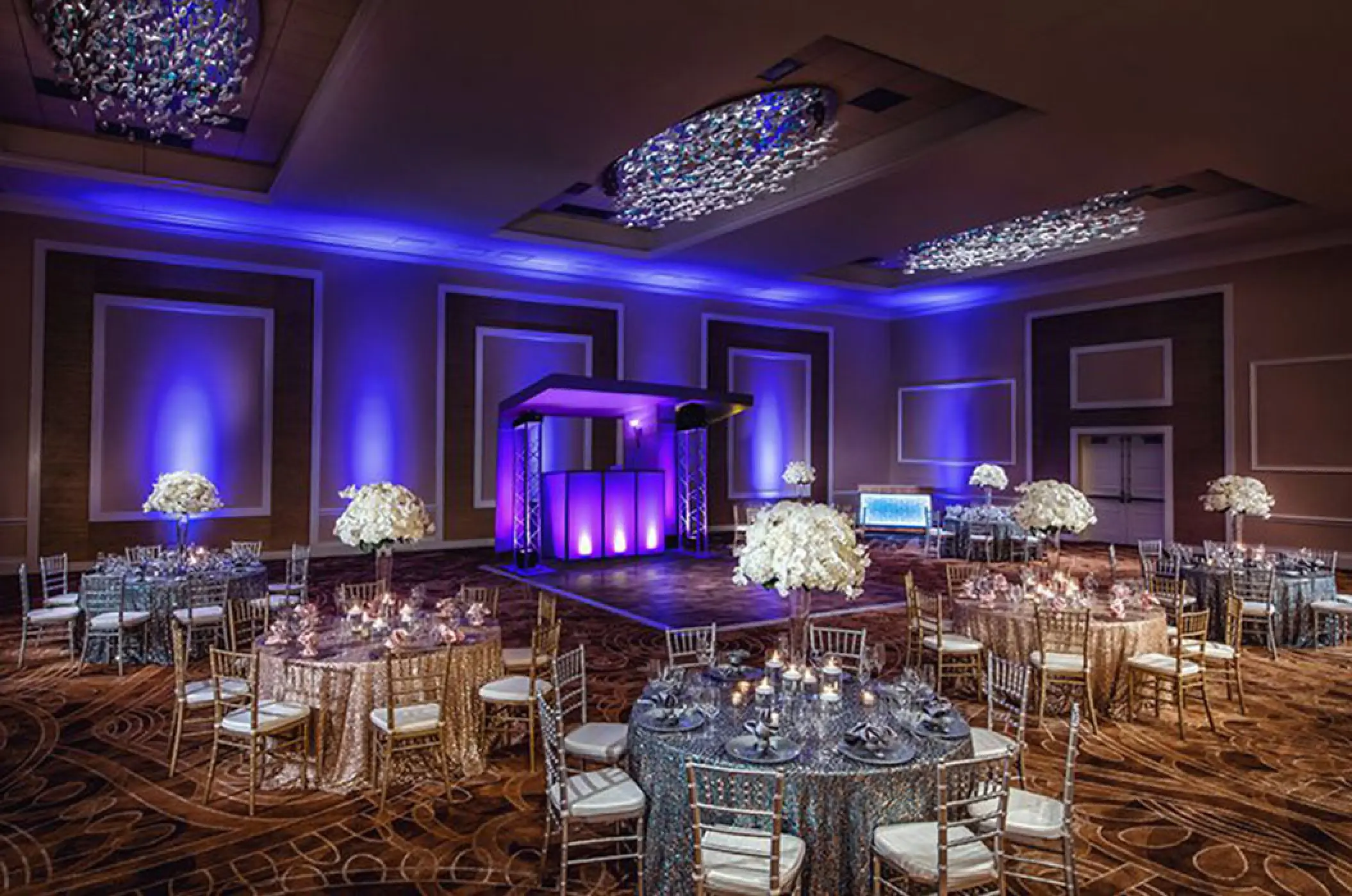Indoor wedding reception with purple lighting and floral centerpieces at Margaritaville Riviera Cancun, Cancun