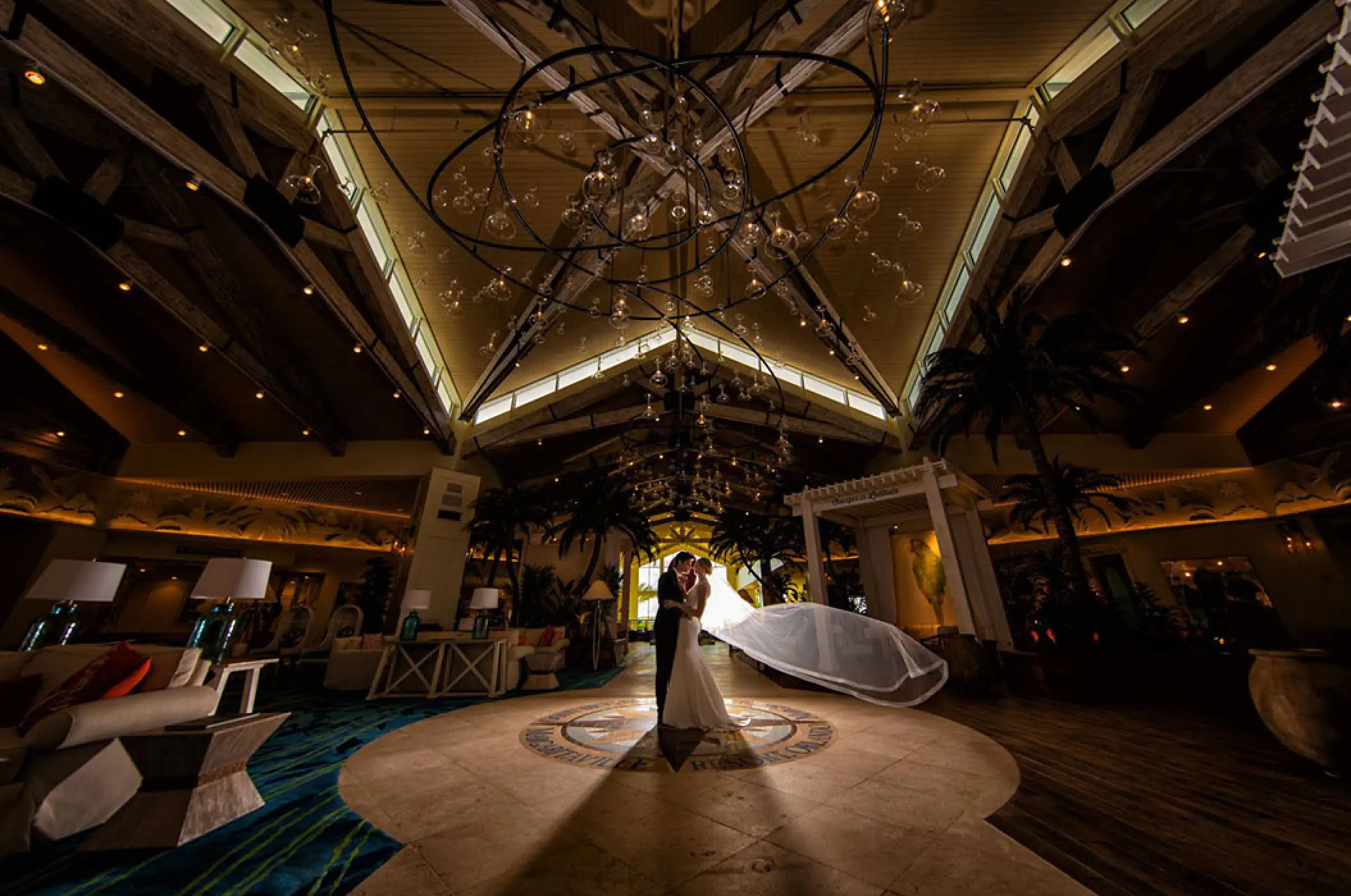 A couple embracing under the high lobby ceiling at Margaritaville Island Reserve Cap Cana, Punta Cana