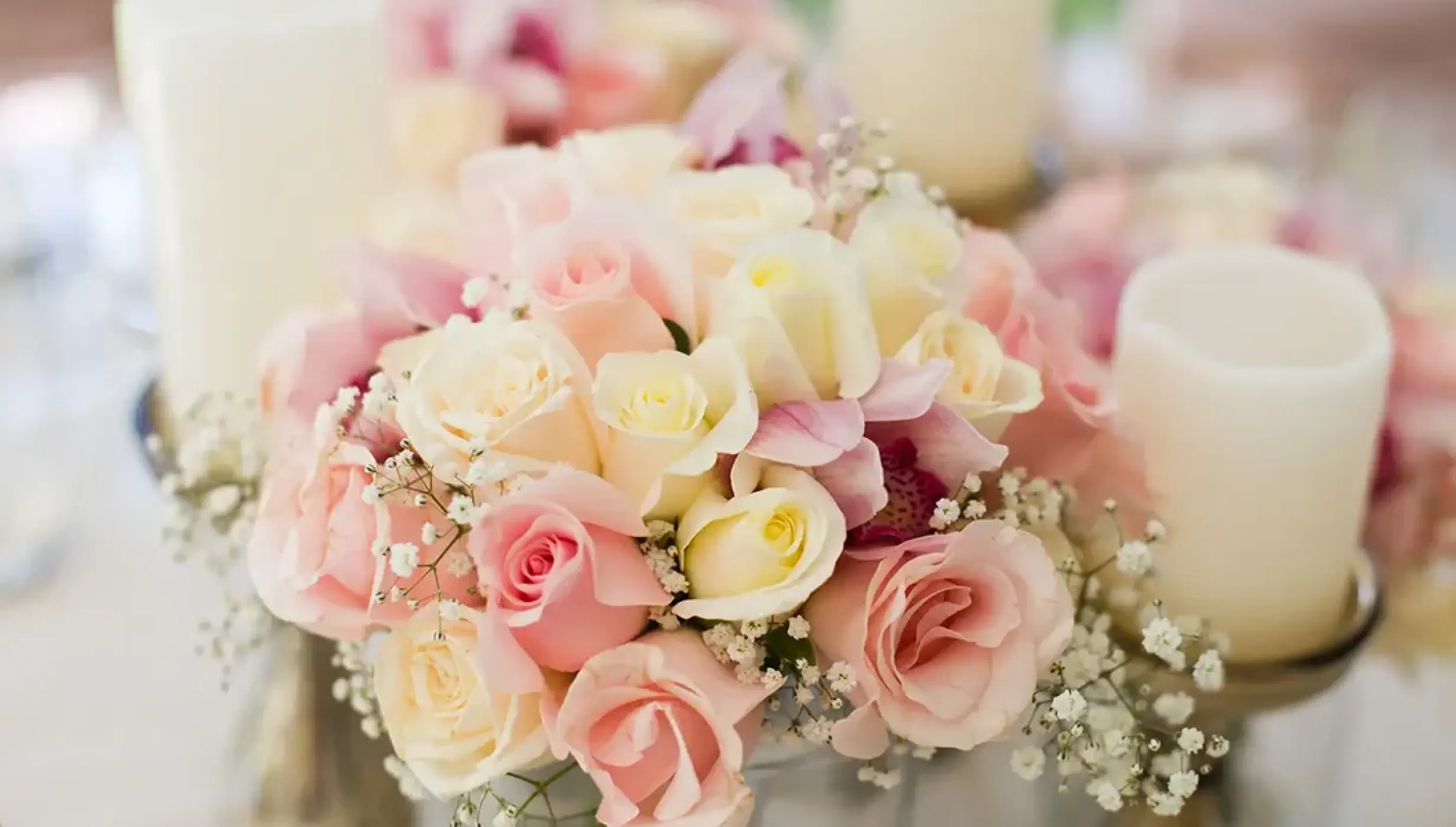 Pink and white rose centerpiece with candles for a wedding reception at Secrets Playa Esmeralda, Miches
