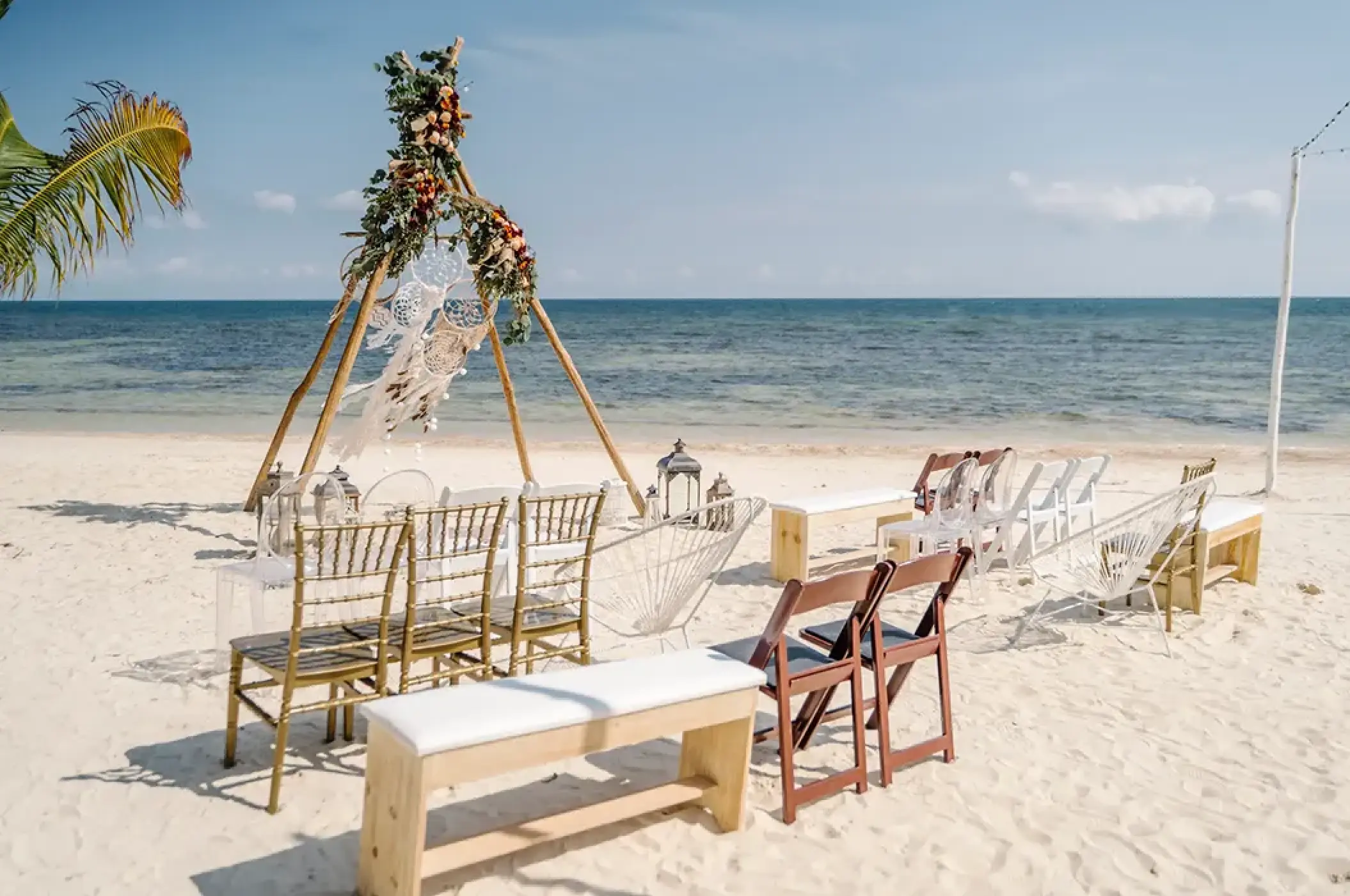 Beachfront wedding ceremony with a teepee arch and mixed seating at Margaritaville Island Reserve Cap Cana, Punta Cana