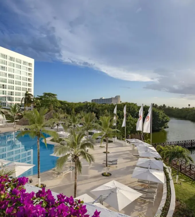 Le Blanc Spa Resort Cancun outdoor pool and lagoon terrace with white umbrellas, Cancun