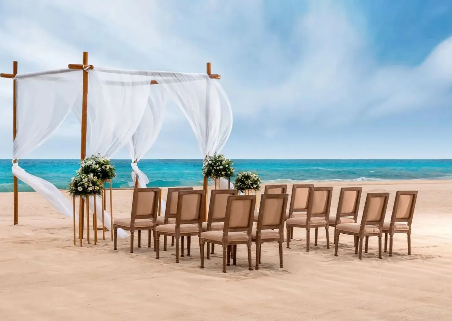 Beach wedding ceremony with white huppah and wooden chairs at Le Blanc Spa Resort, Cancun