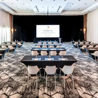 Blanc Breeze Ballroom with banquet tables and a projection screen at Le Blanc Spa Resort, Cancun