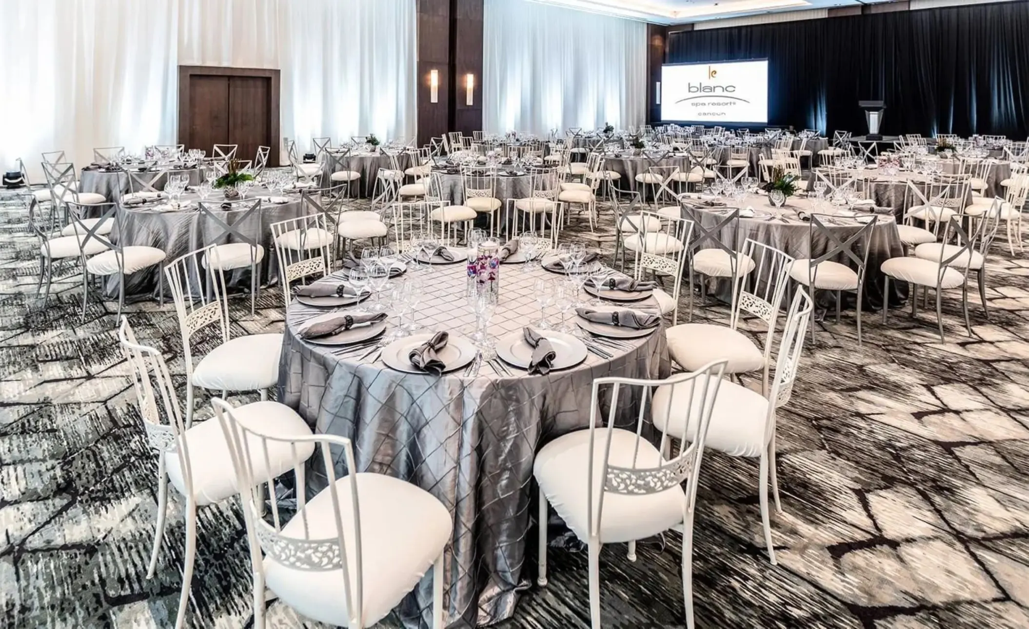 Indoor wedding reception setup with silver linens in the Blanc Sand Ballroom at Le Blanc Spa Resort, Cancun