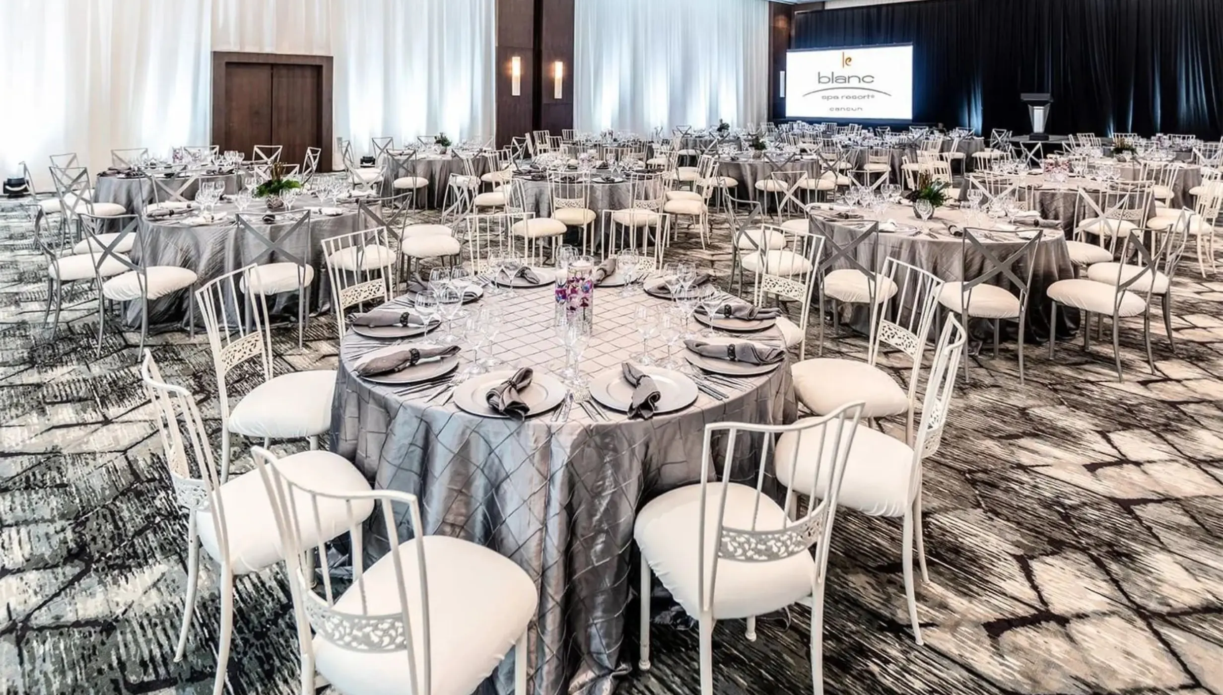 Indoor wedding reception setup with silver linens in the Blanc Sand Ballroom at Le Blanc Spa Resort, Cancun