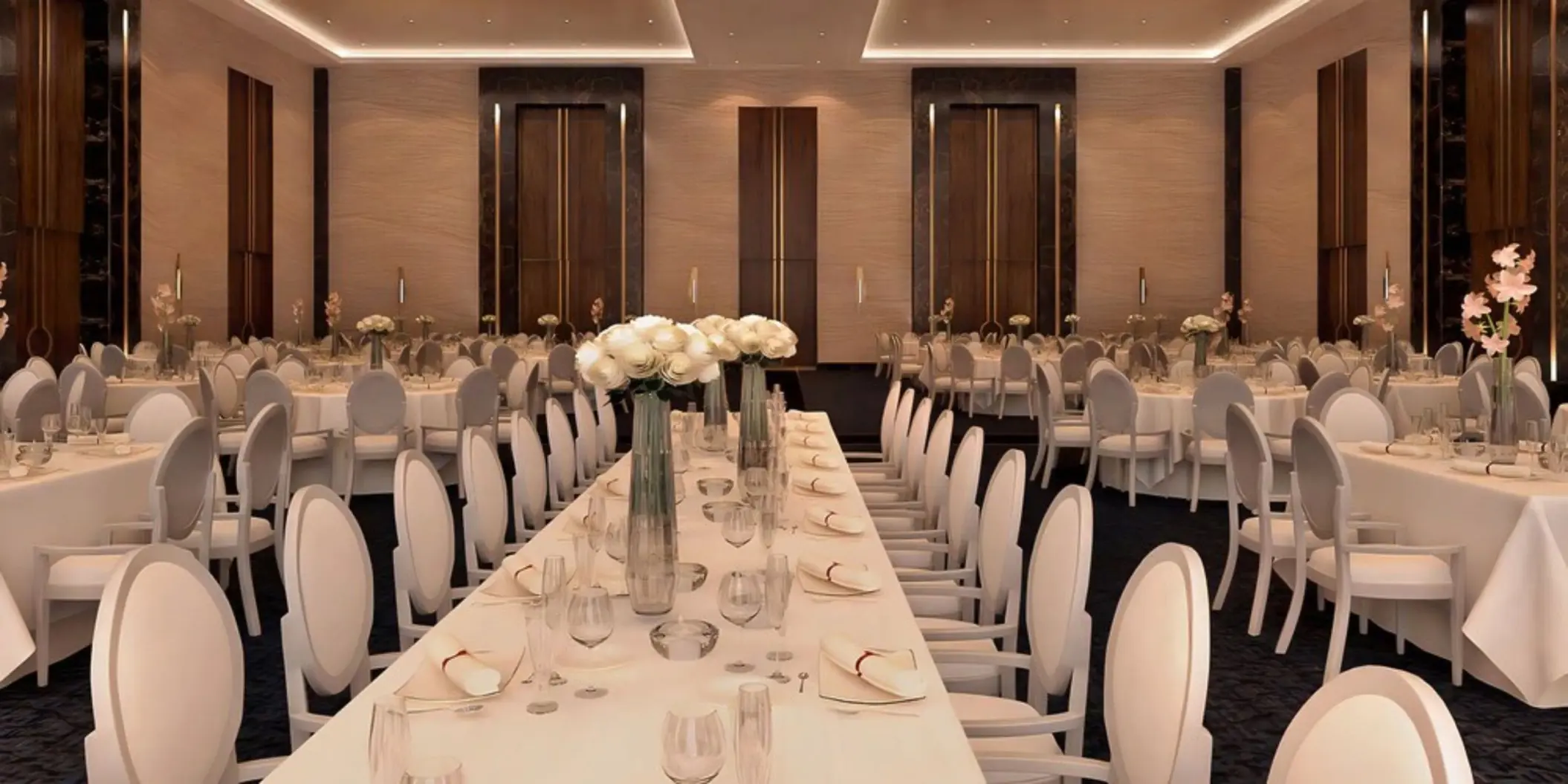 Indoor wedding reception setup with long tables and white floral centerpieces at Le Blanc Spa Resort, Cancun