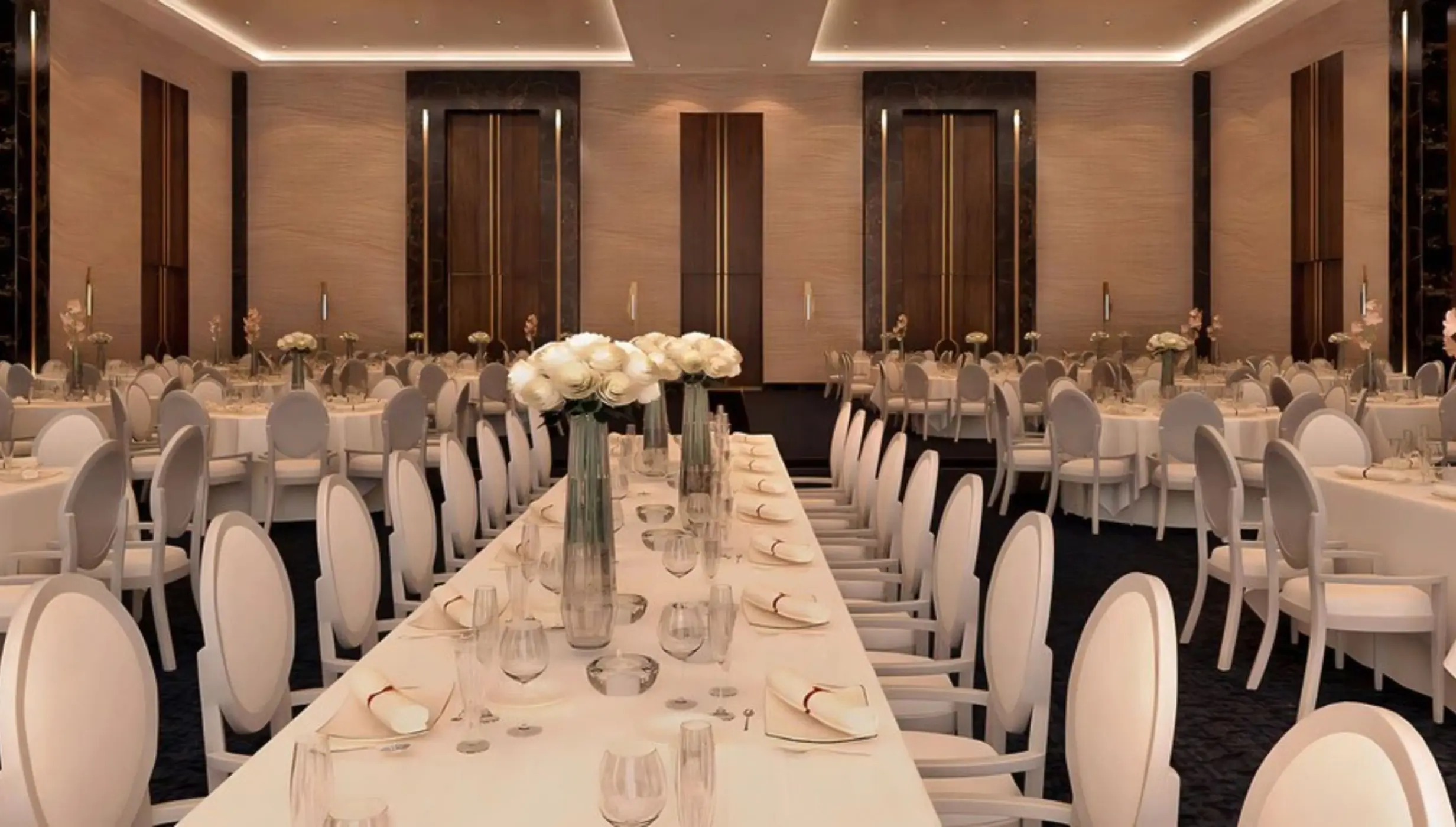 Indoor wedding reception setup with long tables and white floral centerpieces at Le Blanc Spa Resort, Cancun