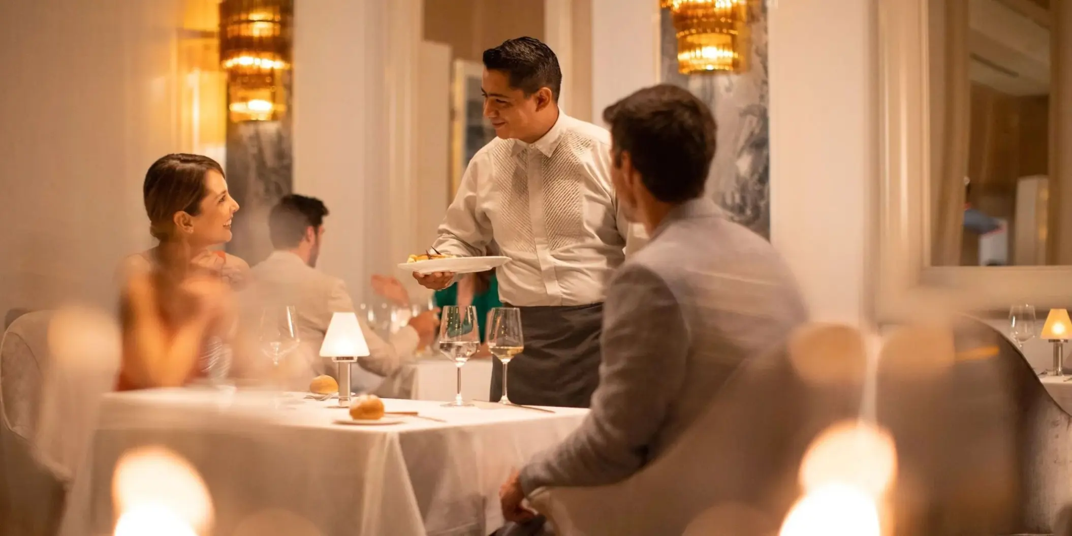 Waiter serving a couple at a fine dining restaurant in Le Blanc Spa Resort, Cancun
