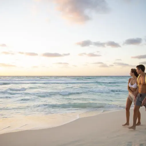Couple walking along the shore at sunset at Le Blanc Spa Resort, Cancun