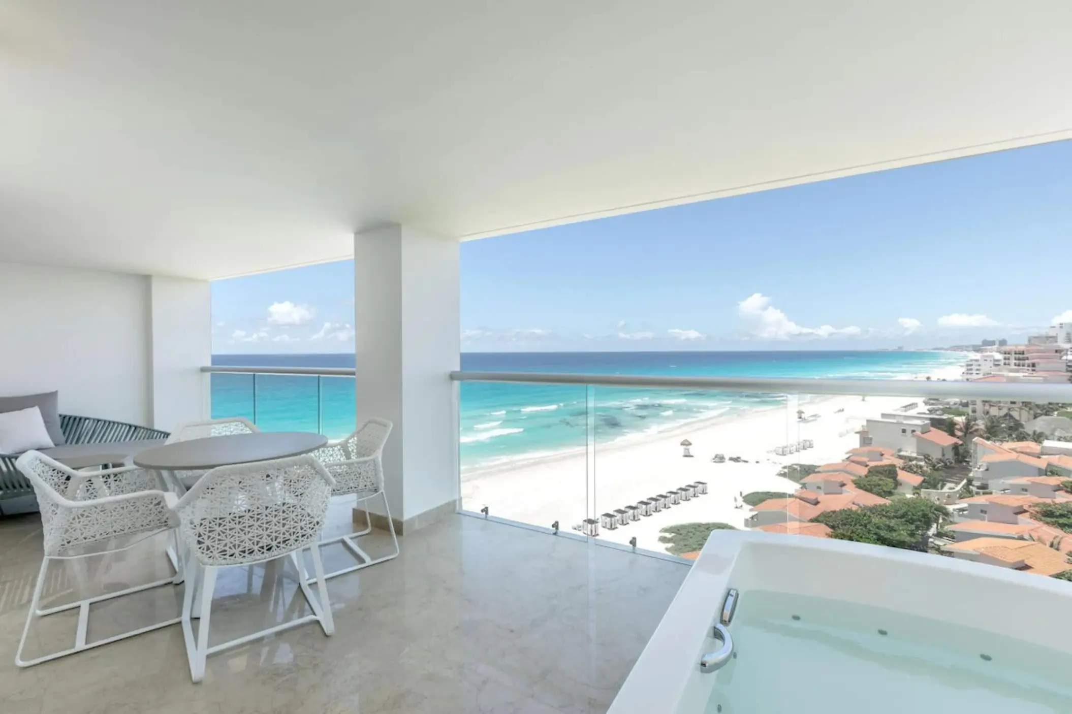 Private balcony with a jacuzzi and dining area at Le Blanc Spa Resort, Cancun