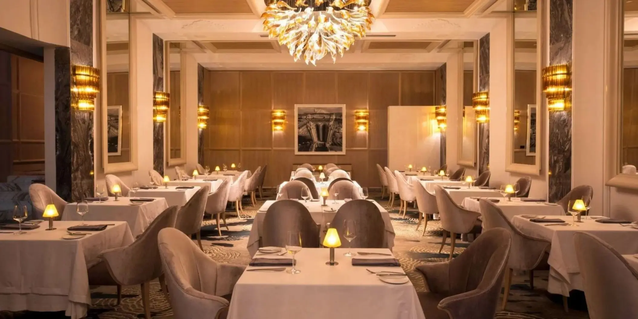 Lumiere restaurant with white tablecloths and a gold chandelier at Le Blanc Spa Resort, Cancun