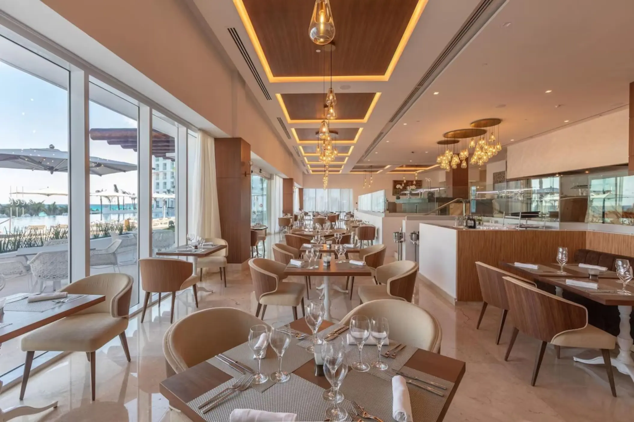 Indoor restaurant with large windows overlooking the pool at Le Blanc Spa Resort, Cancun