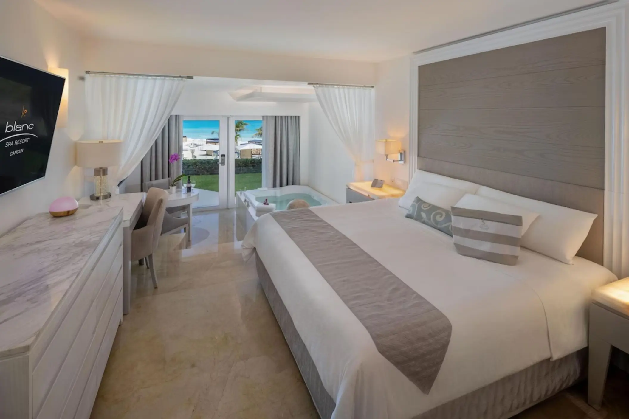 Royale walk-out suite with a whirlpool tub and garden view at Le Blanc Spa Resort, Cancun