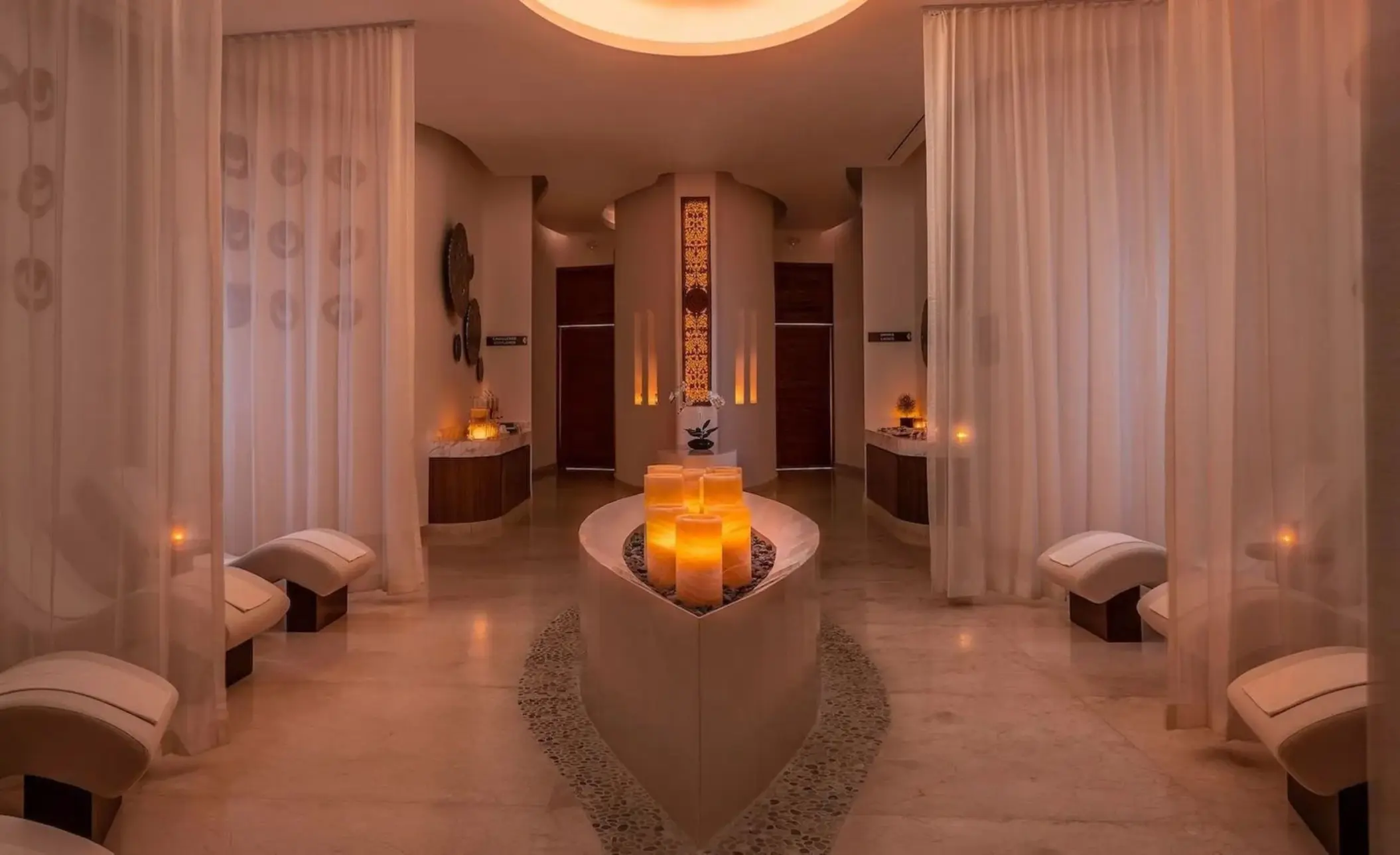 Spa relaxation area with white curtains and candles at Le Blanc Spa Cancun