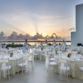 Outdoor wedding reception setup on the Wind Terrace at Le Blanc Spa Resort Cancun during sunset